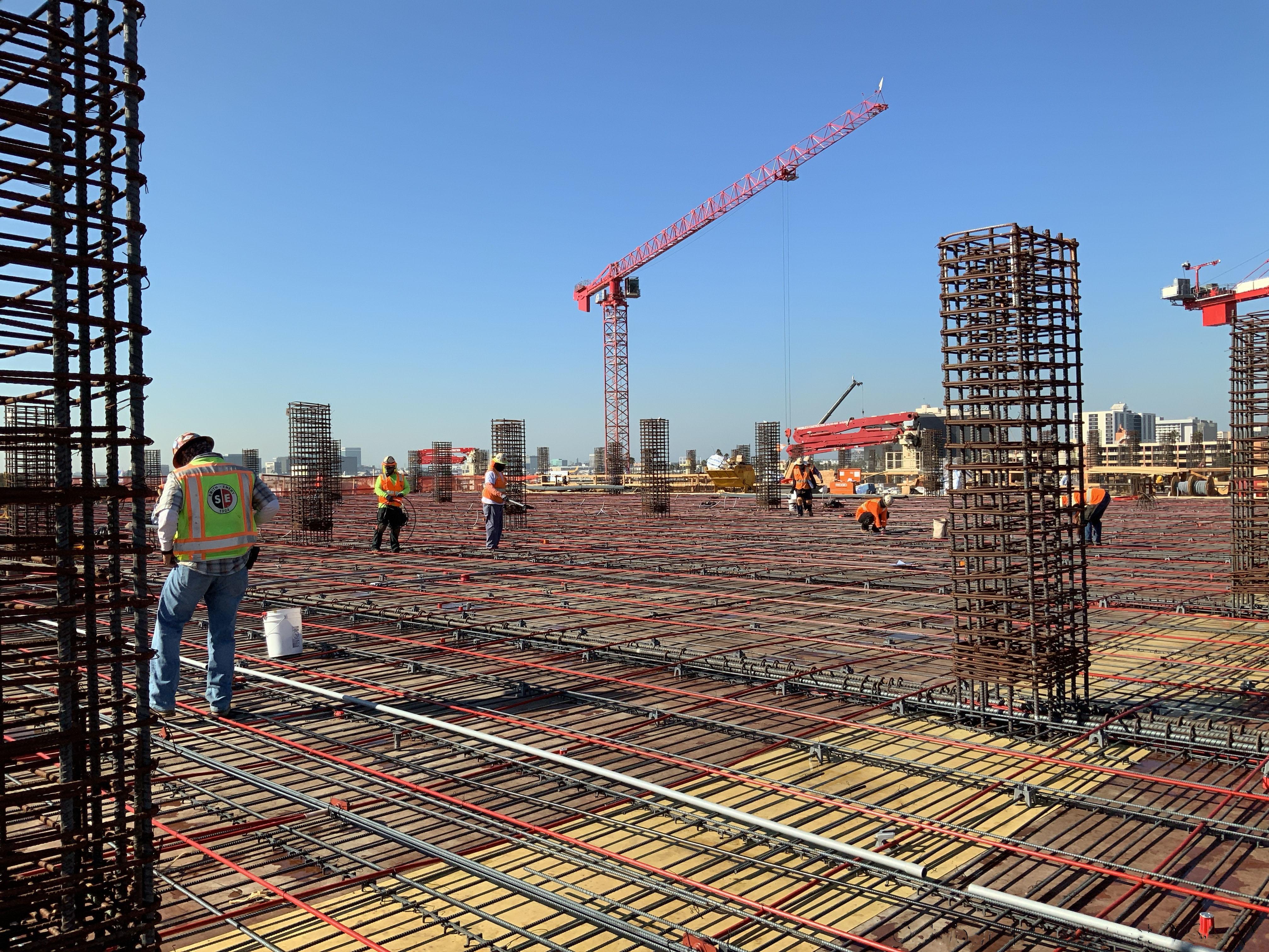 Electricians and iron workers fine tuning the conduits and rebar for the deck the day before a Level 4 deck pour at the Consolidated Rent-A-Car (ConRAC) Facility Ready Return (RR) Building.