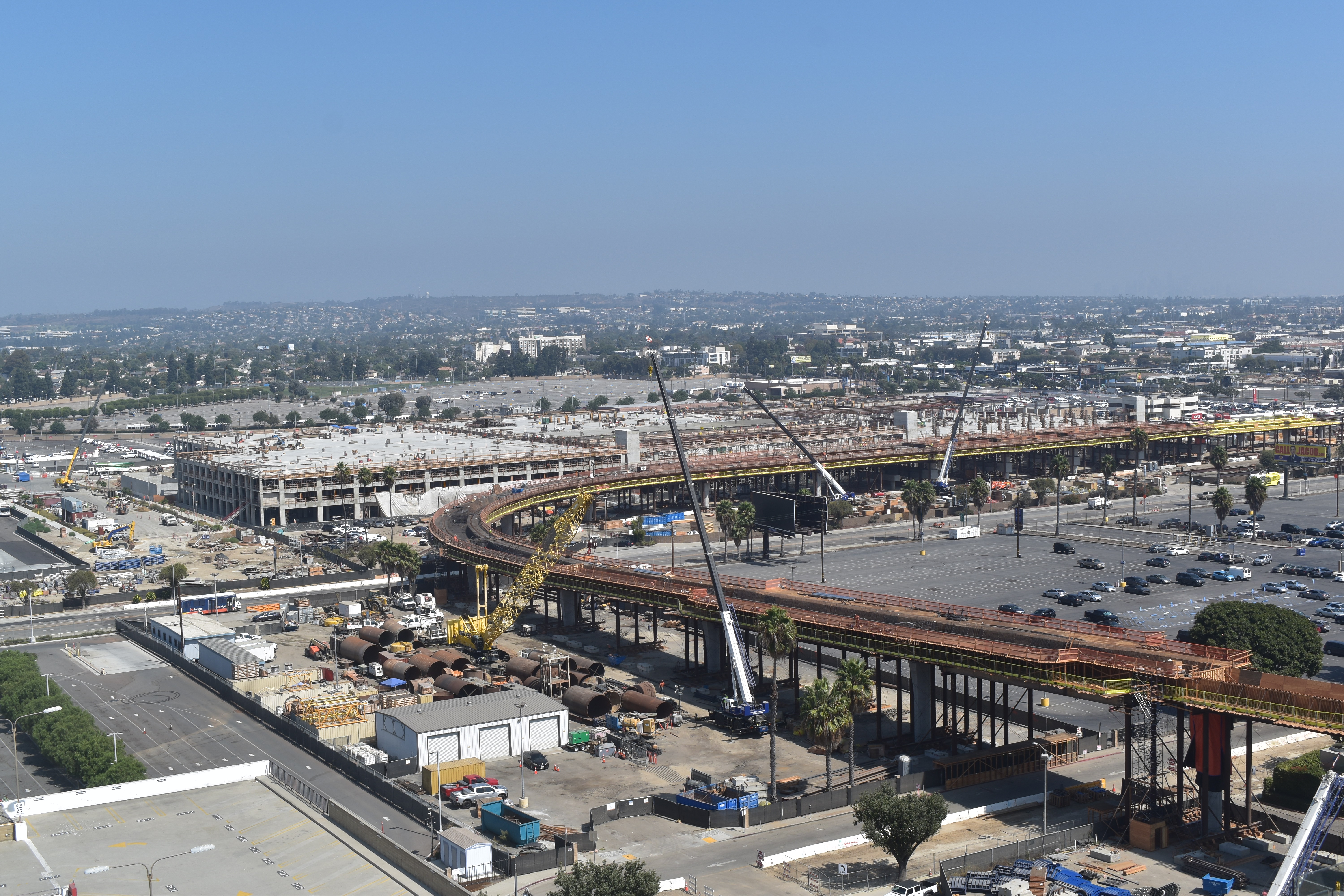An aerial view of construction at the Intermodal Transportation Facility-West and the APM guideway as it curves from 96th Street to future Jetway Boulevard.